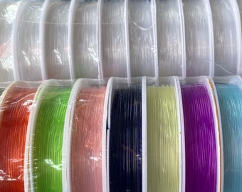 May include: Assortment of spools of colorful elastic cord, including black, white, red, green, pink, blue, yellow, and purple. The spools are wrapped in clear plastic.