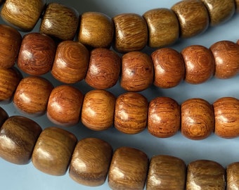 May include: A close-up of a wooden beaded necklace with brown and reddish-brown beads. The beads are round and have a smooth, polished finish.