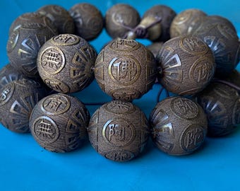 Puede incluir: Un brazalete de cuentas de madera marrón oscuro con intrincados tallados y caracteres chinos. Las cuentas son redondas y tienen un acabado liso y pulido.