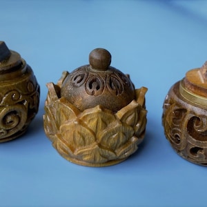 Puede incluir: Tres cajas de madera talladas con intrincados diseños florales y geométricos. Las cajas son de color marrón y tienen un acabado de madera natural.