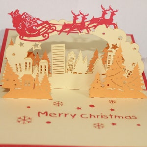 Cartões pop-up de Natal/ Cartão pop-up Papai Noel e o trenó/ Papai Noel voando sobre a cidade
