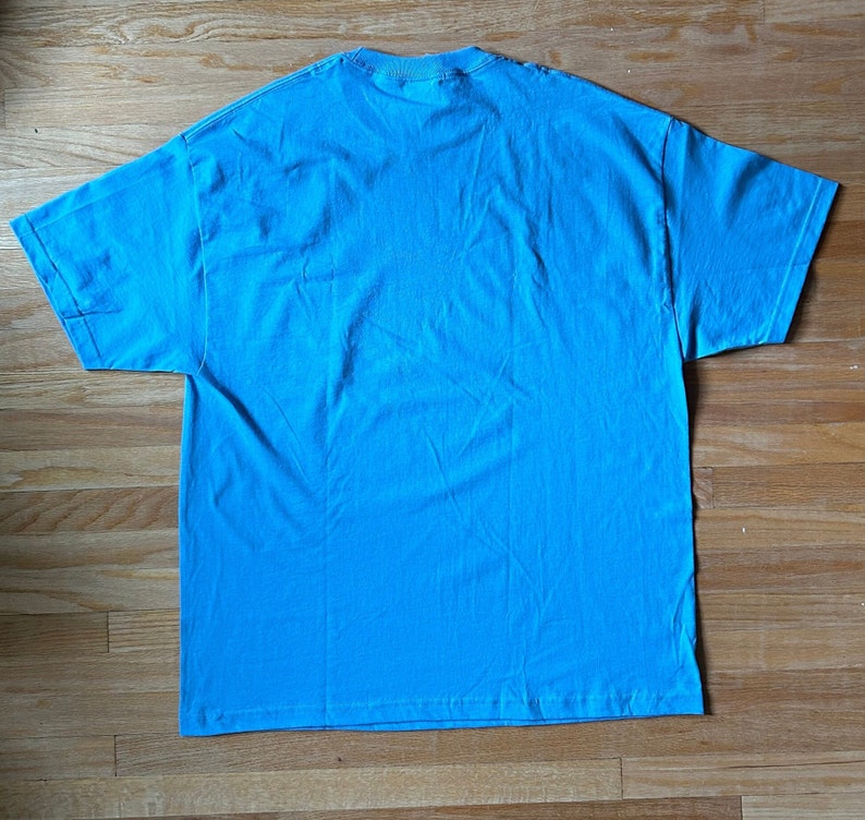 May include: A plain, light blue t-shirt. The shirt is made of a soft, comfortable material.