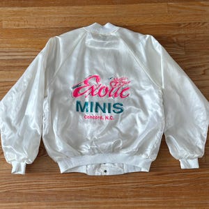 May include: White satin bomber jacket with a pink and green embroidered logo that says "Exotic Minis Concord, N.C."