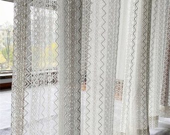 May include: White lace curtains with a geometric pattern. The curtains are sheer and delicate, and they would add a touch of elegance to any room.
