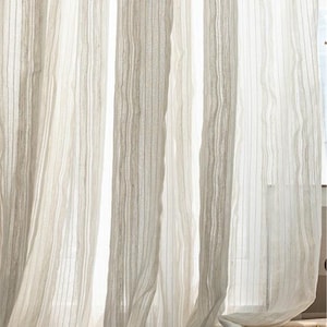 Puede incluir: Cortinas blancas y transparentes con rayas verticales. Las cortinas están hechas de una tela ligera y tienen un brillo sutil.