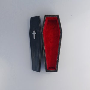 Schwarzer Zehengreifer mit weißem Kreuz und rotem Samtfutter