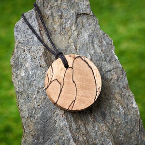 Round Wooden pendant made from Spalted Beech that is hung on a waxed Cotton Thong