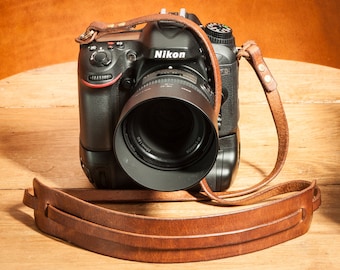 Hand made in the UK. Chestnut leather double brass riveted camera strap with moveable shoulder pad.