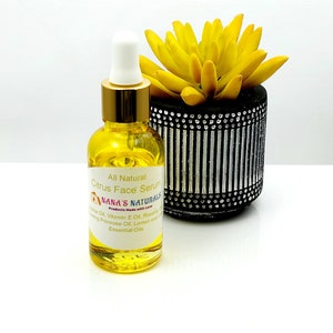 May include: A glass bottle of citrus face serum with a gold lid and dropper. The bottle is labelled "All Natural Citrus Face Serum" and "NANA'S NATURALS Products Made with Love". The ingredients listed are Evening Primrose Oil, Lemon and Lime Essential Oils, Vitamin E Oil, Rosehip Oil.