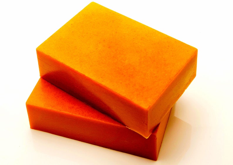 May include: Two rectangular bars of orange soap stacked on top of each other.