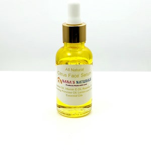 May include: A glass bottle of all-natural citrus face serum with a gold lid and dropper. The label reads "All Natural Citrus Face Serum" and "NANA'S NATURALS Products Made with Love". The ingredients listed are jojoba oil, vitamin E oil, rosehip oil, evening primrose oil, lemon and lime essential oils.