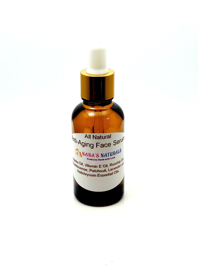May include: A brown glass bottle with a gold lid and a white dropper top. The bottle is labeled "All Natural Anti-Aging Face Serum" and "NANA'S NATURALS Products Made with Love". The label also lists the ingredients: Jojoba Oil, Vitamin E Oil, Rosehip Oil, Frankincense, Patchouli, Lavender and Helichrysum Essential Oils.