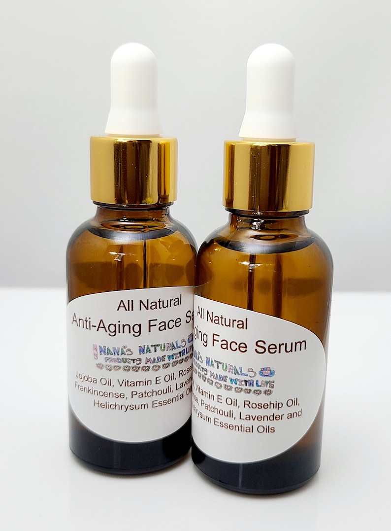 May include: Two amber glass bottles with gold lids and white droppers filled with a clear liquid. The bottles have white labels with black text that reads "All Natural Anti-Aging Face Serum" and "NANA'S NATURALS PRODUCTS MADE WITH LOVE".