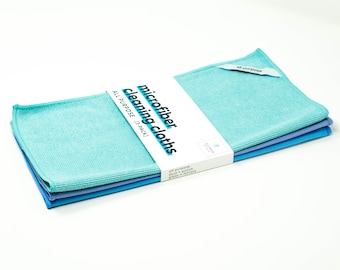 May include: A pack of three microfiber cleaning cloths in blue and turquoise colors. The packaging says "microfiber cleaning cloths" and "all purpose (3 pack)".