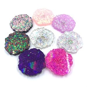 May include: Assortment of seven round, iridescent glitter resin coasters in various colors, including pink, purple, green, and blue.