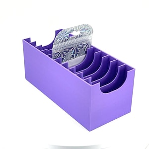 May include: Purple plastic storage organizer with multiple compartments for holding small items. The organizer has a clear plastic insert with a holographic pattern.