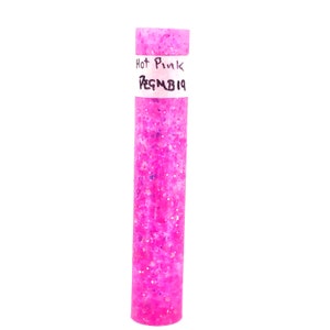 May include: A clear tube filled with hot pink glitter. The tube has a white label with the text "Hot Pink" and "PEGMB19" written on it.