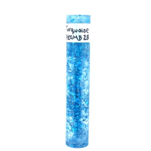May include: A turquoise blue resin casting with a label that reads "Turquoise PEGM B 28". The resin is filled with small, iridescent glitter.