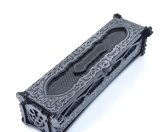 May include: A rectangular black box with ornate silver floral designs. The box has a textured surface and a central handle. The corners feature decorative elements, and the overall design is symmetrical and detailed.