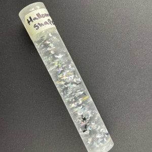 May include: A clear glass rolling pin with a label that says "Halloween Shakers" and black and silver glitter inside.