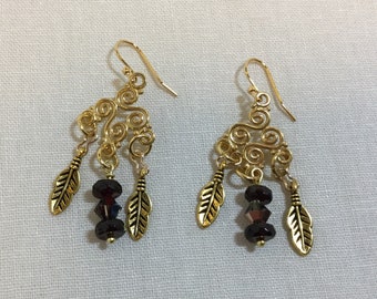 Gold chandelier earrings with garnet rondels and feathers