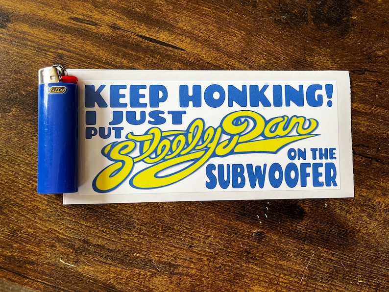 May include: White sticker with blue and yellow text that reads "Keep Honking! I Just Put "Skooly Dan" On The Subwoofer".