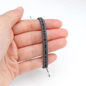 Op de afbeelding: Een zwarte en zilveren kralen armband met een eenvoudig ontwerp.