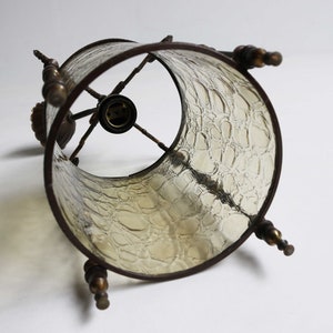 Pode incluir: Um abajur de estilo vintage com um design de vidro texturizado. O abajur &eacute; feito de vidro transparente com uma moldura de metal marrom e detalhes decorativos. O abajur &eacute; projetado para ser usado com uma l&acirc;mpada padr&atilde;o.