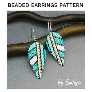 May include: A pair of turquoise, white, black, and gold beaded earrings in the shape of a leaf. The earrings are hanging from silver hooks. The earrings are on a brown wooden surface. "by Galiga" is written in white text on a white background below the earrings.