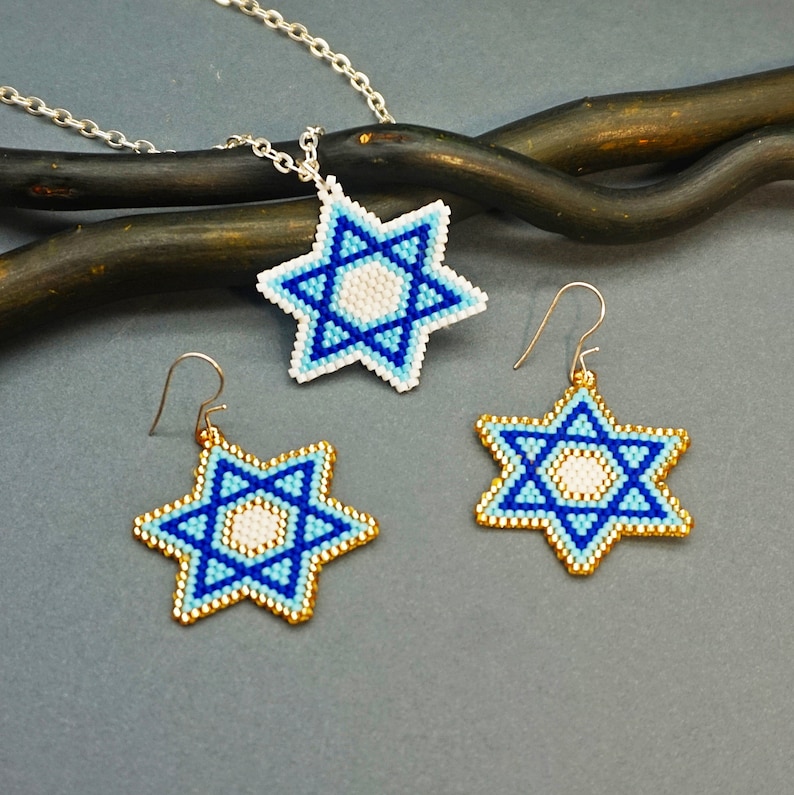 May include: A beaded Star of David necklace and earrings set. The necklace has a silver chain and the pendant is a blue and white beaded star. The earrings are blue and white beaded stars with gold hooks.
