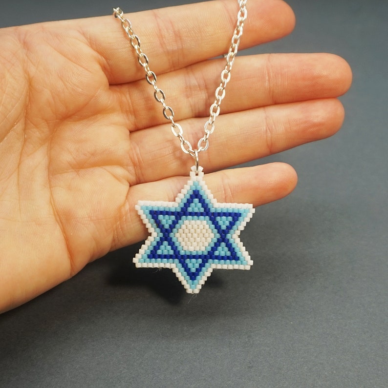 May include: A silver chain necklace with a blue and white beaded Star of David pendant.