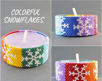 May include: A colorful beaded tea light candle cover with a snowflake pattern. The cover is made of rainbow colored beads and features white snowflakes. The text "Colorful Snowflakes" and "Christmas DIY" are visible in the image.