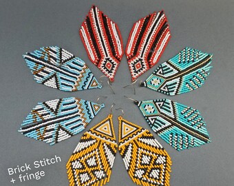 May include: Set of four pairs of beaded fringe earrings in various geometric patterns. The earrings are made with black, white, red, blue, and yellow beads. The earrings are labeled "Brick Stitch + fringe" and "by Galiga".