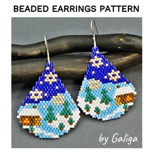 May include: Beaded earrings with a winter scene pattern. The earrings are blue, white, green, and brown. The pattern includes snowflakes, trees, and houses. The earrings are labeled "by Galiga".