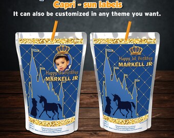 Pode incluir: Duas etiquetas Capri Sun com tema de príncipe real. As etiquetas são azuis com detalhes dourados, uma silhueta de castelo e uma foto de um bebê. O texto diz "Happy 1st Birthday MARKELL JR". Cada saquinho tem um canudo.