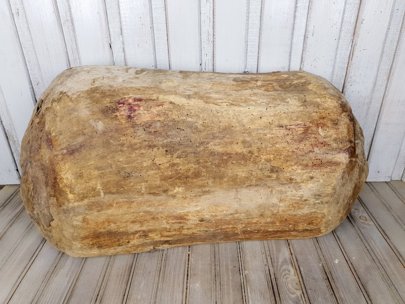 K&ouml;nnte beinhalten: Eine gro&szlig;e, ovale Holz-Teigsch&uuml;ssel mit nat&uuml;rlicher, rustikaler Oberfl&auml;che. Die Sch&uuml;ssel ist hellbraun mit dunkleren braunen Streifen und Flecken.