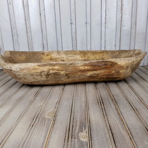 K&ouml;nnte beinhalten: Eine gro&szlig;e, rustikale Holz-Teigsch&uuml;ssel mit nat&uuml;rlicher Holzoptik. Die Sch&uuml;ssel besteht aus einem einzigen St&uuml;ck Holz und hat eine einzigartige, organische Form.