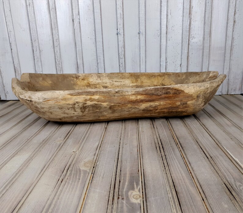 K&ouml;nnte beinhalten: Eine gro&szlig;e, rustikale Holz-Teigsch&uuml;ssel mit nat&uuml;rlicher Holzoptik. Die Sch&uuml;ssel besteht aus einem einzigen St&uuml;ck Holz und hat eine einzigartige, organische Form.