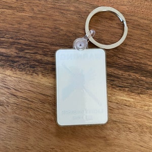 Peut inclure: Un porte-cl&eacute;s en plastique blanc avec un anneau en m&eacute;tal argent&eacute;. Le porte-cl&eacute;s est dot&eacute; d'un couvercle en plastique transparent avec un motif blanc de papillon &agrave; l'int&eacute;rieur. Le texte "Butterfly" est imprim&eacute; sur le porte-cl&eacute;s.