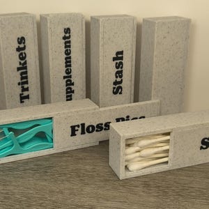 May include: A white ceramic mug with a black handle and the text "But First, Coffee" in a black, bold font. The mug is sitting on a white surface. The mug is 4 inches tall.