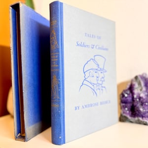 May include: A blue hardcover book titled "Tales of Soldiers and Civilians" by Ambrose Bierce. The book cover features a line drawing of a man in a military uniform and hat.