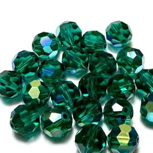 May include: A collection of faceted, emerald green beads. The beads have multiple sides that reflect light, creating a sparkling effect. These beads are suitable for jewelry making and crafting projects.