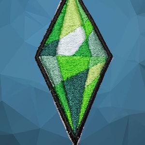 May include: A green diamond-shaped patch with a white circle in the center. The patch is made of fabric and has a black outline.