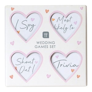 May include: White wooden frame with four pink heart-shaped cutouts. Each cutout has a different wedding game written inside: "I Spy", "Most Likely To", "Shout Out!" and "Trivia".
