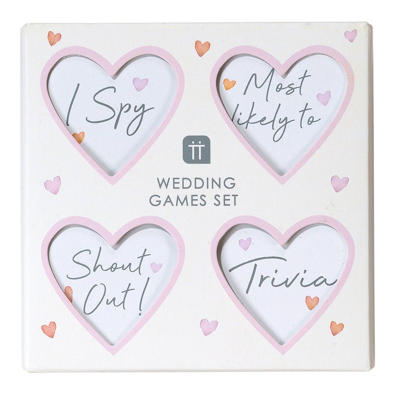 May include: White wooden frame with four pink heart-shaped cutouts. Each cutout has a different wedding game written inside: "I Spy", "Most Likely To", "Shout Out!" and "Trivia".