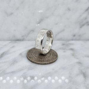 50 sen coin ring from Japan in silver set with a sapphire, an emerald and a diamond (coin ring)