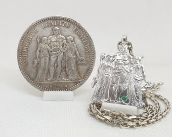 Hand-cut silver 10 Francs "Hercules" coin pendant set with an emerald.