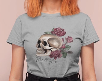 May include: A gray t-shirt with a skull and roses design. The skull is white with brown details and is surrounded by pink roses. The text "Memento Mori" is printed below the skull.