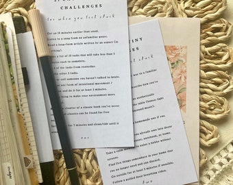 May include: A set of three cards with a light blue background and white text. The cards contain a list of 21 tiny challenges for when you feel stuck. The challenges include getting up 10 minutes earlier than usual, listening to a song from an unfamiliar genre, reading a long-form article written by an expert, and more.