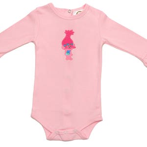 May include: A pink long-sleeved baby onesie with a ruffle trim on the sleeves and a cartoon troll embroidered on the front.